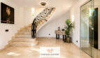 Eleganter Eingangsbereich einer Villa in Sa Torre mit Marmortreppe, Schmiedeeisengitter und Glasfront.