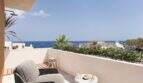 Sonnige Dachterrasse mit Rattansessel, Meerblick, mediterranen Pflanzen und Außendusche in Cala Murada