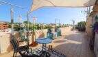 Terraza en la azotea soleada con vela solar, área de descanso y vista al mar del apartamento de 4 hab. en Porto Cristo
