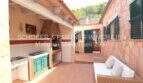 Covered terrace with outdoor kitchen, grill area and lounge sofa at natural stone house in Son Servera