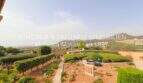 Well-maintained garden with curved hedges, gravel path and panoramic view of mountains and village in Son Servera
