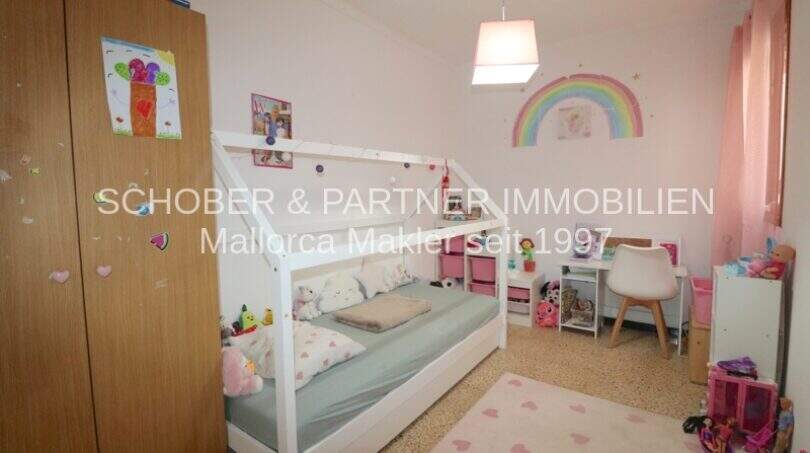 Habitación infantil con cama casita, decoración arco iris y acentos rosa en cuidado apartamento de 4 habitaciones en Porto Cristo