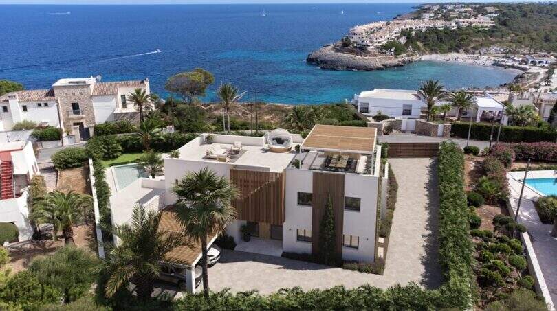 Luftaufnahme der modernen Designvilla mit Rooftop-Terrasse, Pool und direktem Meerblick auf die Bucht von Cala Murada.