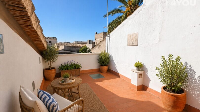 Sonnige Dachterrasse mit Terrakottafliesen, Rattanmöbeln und Topfpflanzen, Stadthaus Petra Mallorca