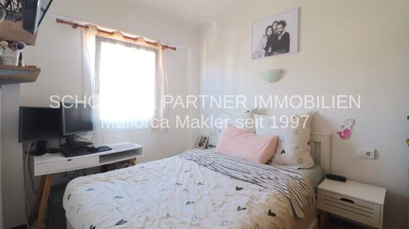Luminoso dormitorio del apartamento de 4 habitaciones en Porto Cristo con cama doble, escritorio y ventana.