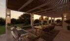 Überdachte Außenterrasse mit Pergola, Essbereich und Outdoorküche bei Sonnenuntergang, Designvilla Cala Murada