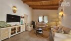 Bright living room with wooden beam ceiling, sofa group, TV cabinet and Mediterranean decoration in bungalow Alcúdia.