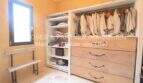 Begehbarer Kleiderschrank mit Hängestange, Holzkommode und Regalflächen im sanierten Landhaus Port de Manacor