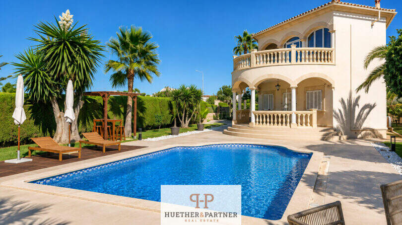 Villa Sa Torre Llucmajor: Mediterrane Außenansicht mit Pool, Palmen, Terrasse und elegantem Balkon bei blauem Himmel.