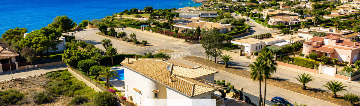 Luftaufnahme einer mediterranen Villa in Sa Torre mit Pool, Palmengarten und spektakulärem Meerblick in Llucmajor