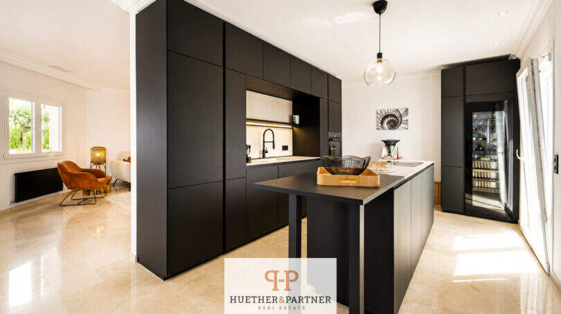Moderne Küche mit schwarzen Einbauschränken, Kücheninsel und Weinkühlschrank in Villa Sa Torre, Llucmajor