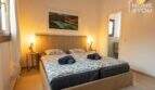 Schlafzimmer mit Doppelbett, Nachttischlampen und En-suite-Bad im Bungalow in Alcúdia