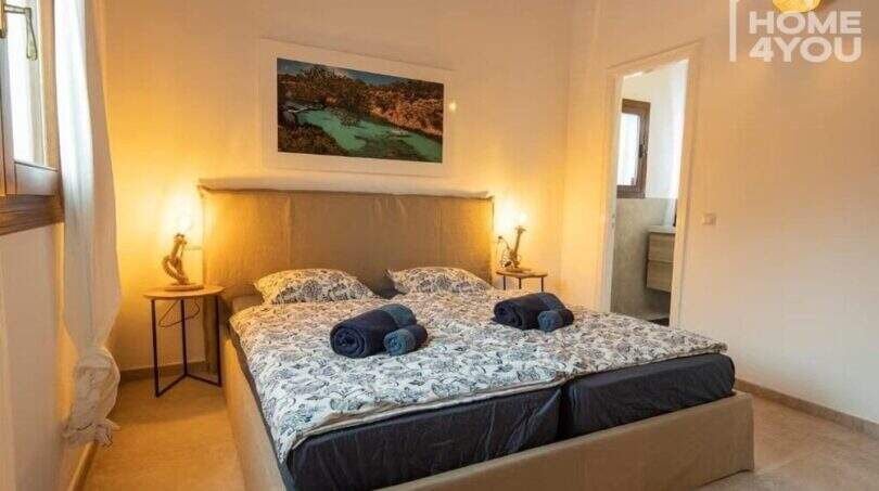 Schlafzimmer mit Doppelbett, Nachttischlampen und En-suite-Bad im Bungalow in Alcúdia
