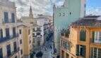 Vista desde apartamento del casco antiguo a la bulliciosa zona peatonal de Palma con edificios históricos y catedral al fondo
