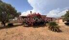 Außenansicht der Finca in Llucmajor mit üppiger Bougainvillea, Terrassenüberdachung und mediterranem Garten.
