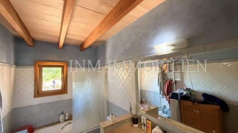 Badezimmer der Finca Llucmajor mit Holzbalkendecke, Badewanne, WC und Waschbecken mit Spiegel
