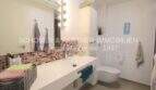 Modernes Badezimmer mit großem Waschtisch, Mosaik-Fliesenspiegel und WC in Garten-Eck-Wohnung Sa Coma