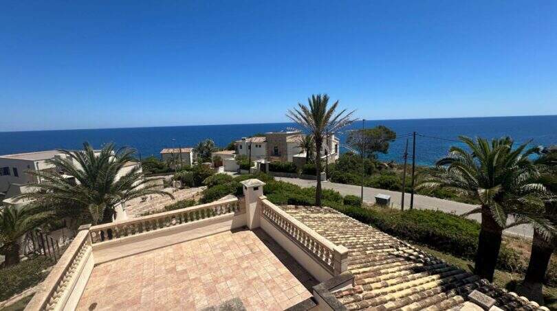 Dachterrasse der Meerblick-Villa in Cala Murada mit Balustrade, Palmen und direktem Blick aufs Mittelmeer.