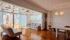 Helles Wohnzimmer der Dachgeschosswohnung Blanquerna mit Parkettboden, Balkon und bunter Deckengestaltung