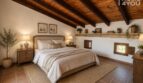 Schlafzimmer mit Holzbalkendecke, Natursteinsims, Terrakottaboden und mediterranem Landhausstil in Petra.