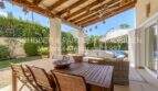 Überdachte Terrasse mit Holzbalken, Esstisch, Loungebereich und Poolblick der mediterranen Villa in Sa Coma