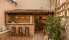 Mediterraner Patio mit rustikaler Außenbar, Natursteinwänden, Barhockern und Terrakottadach in Stadthaus Petra