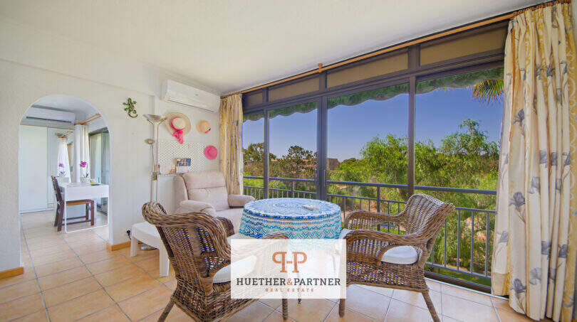 Heller Wohnbereich mit Korbmöbeln, Panoramafenster und Gartenblick in Apartment Cales de Mallorca