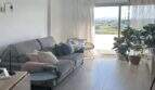 Helles Wohnzimmer des Penthouses in Portitxol mit grauem Sofa, Panoramafenster und Meerblick