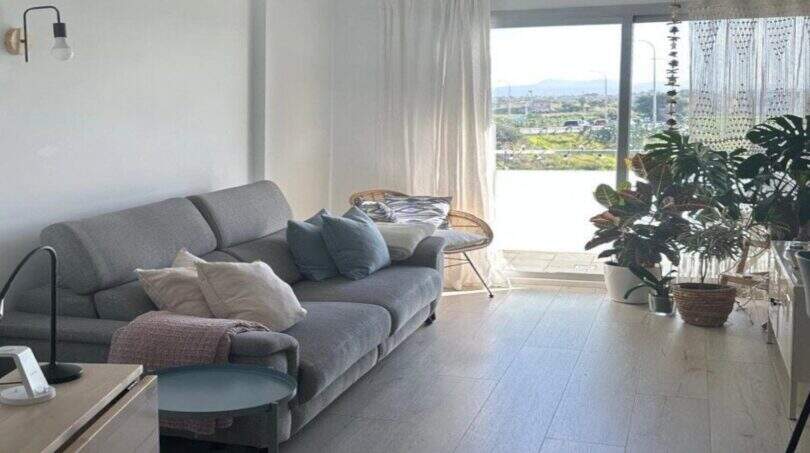 Helles Wohnzimmer des Penthouses in Portitxol mit grauem Sofa, Panoramafenster und Meerblick