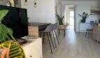 Helles Wohnzimmer mit Holzboden, Hängeleuchten, TV-Möbel und Zimmerpflanzen im Penthouse Portitxol