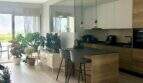 Offene Küche mit Holzinsel, Pendelleuchten und Pflanzen im Penthouse Portitxol, Palma de Mallorca