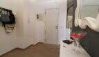 Heller Eingangsbereich der Penthouse-Maisonette in Palma mit weißer Tür, Garderobe und elegantem Dekospiegel.