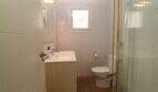 Helles Badezimmer mit Glasdusche, Waschbecken, WC und Holzboden im Penthouse Palma