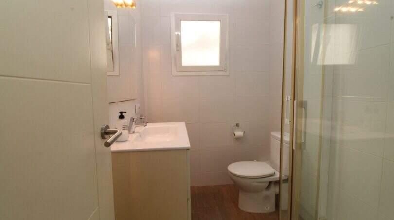 Helles Badezimmer mit Glasdusche, Waschbecken, WC und Holzboden im Penthouse Palma