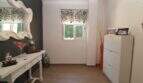 Heller Eingangsbereich der Maisonette mit weißem Konsolentisch, elegantem Spiegel und modernem Schuhschrank