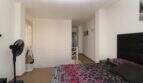 Helles Schlafzimmer der Penthouse-Maisonette mit Doppelbett, schwarzem Kopfteil und Galeriebereich mit Treppenaufgang.
