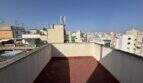 Dachterrasse des Penthouses mit rotem Belag und Panoramablick über die Dächer von Palma de Mallorca