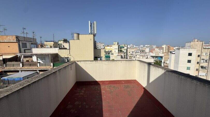 Dachterrasse des Penthouses mit rotem Belag und Panoramablick über die Dächer von Palma de Mallorca