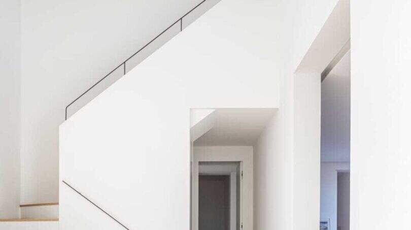 Helles Treppenhaus mit Holzstufen, weißen Wänden und minimalistischem Design im eleganten Anwesen in Marratxí.