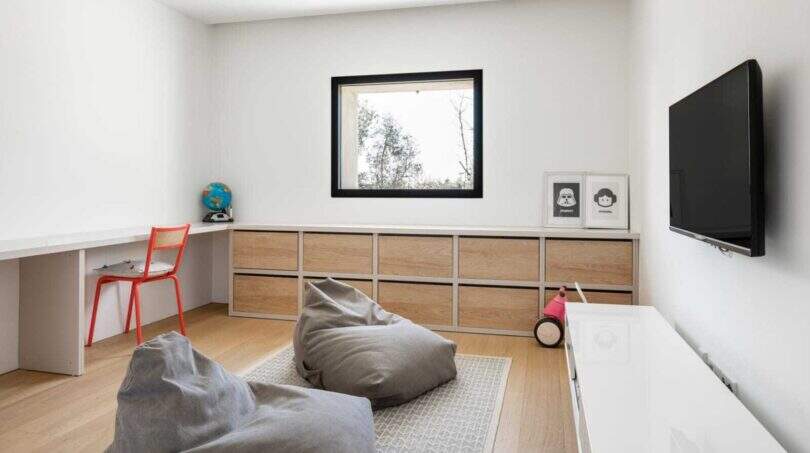 Kinderzimmer mit Holzkommode, Beanbags, Schreibtisch und Wandtv in modernem Anwesen in Marratxí.