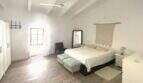 Helles Schlafzimmer mit Doppelbett, Makramee-Wanddeko, Holzboden und Deckenventilator im Stadthaus Sencelles