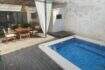 Sunny terrace with wooden deck, blue mosaic pool and covered dining area in Sencelles