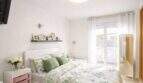 Bright bedroom of the ground floor apartment in Palma with double bed, floral bedding and terrace access.