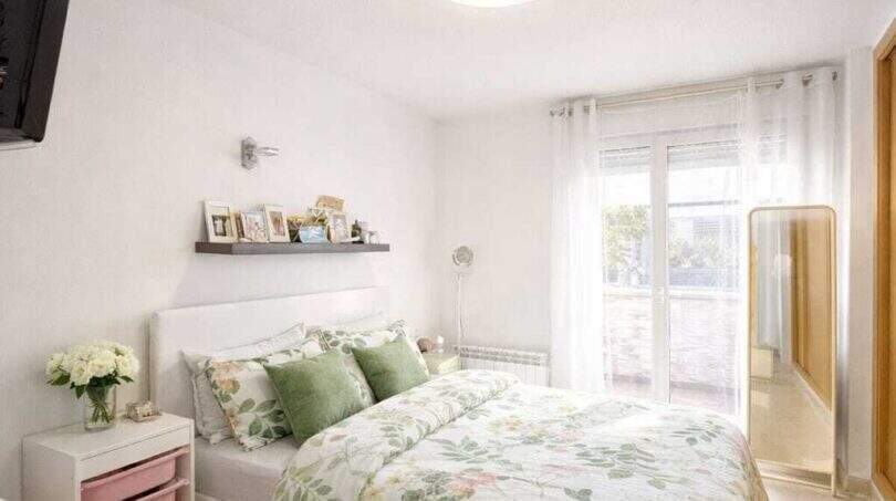 Bright bedroom of the ground floor apartment in Palma with double bed, floral bedding and terrace access.