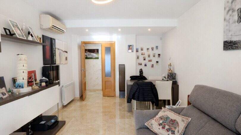 Bright living room with designer lamp, marble floors, gray sofa and modern TV area in ground floor apartment Palma