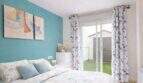Bright bedroom with turquoise accent wall, double bed and terrace access to the garden, ground floor apartment Palma