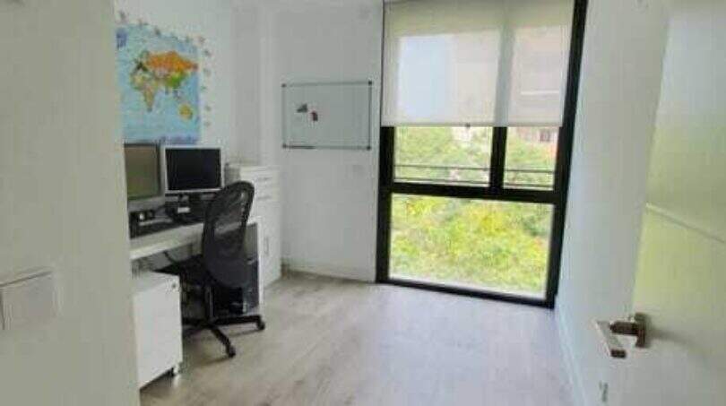 Helles Arbeitszimmer mit Holzboden, Schreibtisch, Weltkarteund großem Fenster mit Grünblick im Penthouse Palma.