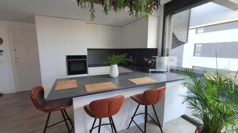 Modernes Penthouse-Küche in Palma mit Kochinsel, Barhockern und Begrünung an der Decke