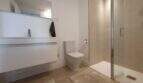 Modernes Badezimmer im Penthouse Nou Llevant mit Dusche, WC und schwebenden Waschtisch in Weiß.