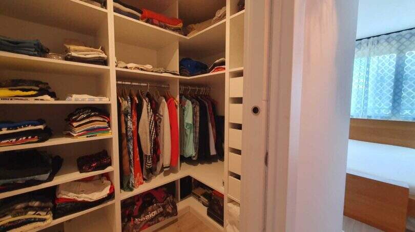 Begehbarer Kleiderschrank mit weißen Regalen, Kleiderstange und Schubladen im Penthouse Nou Llevant, Palma